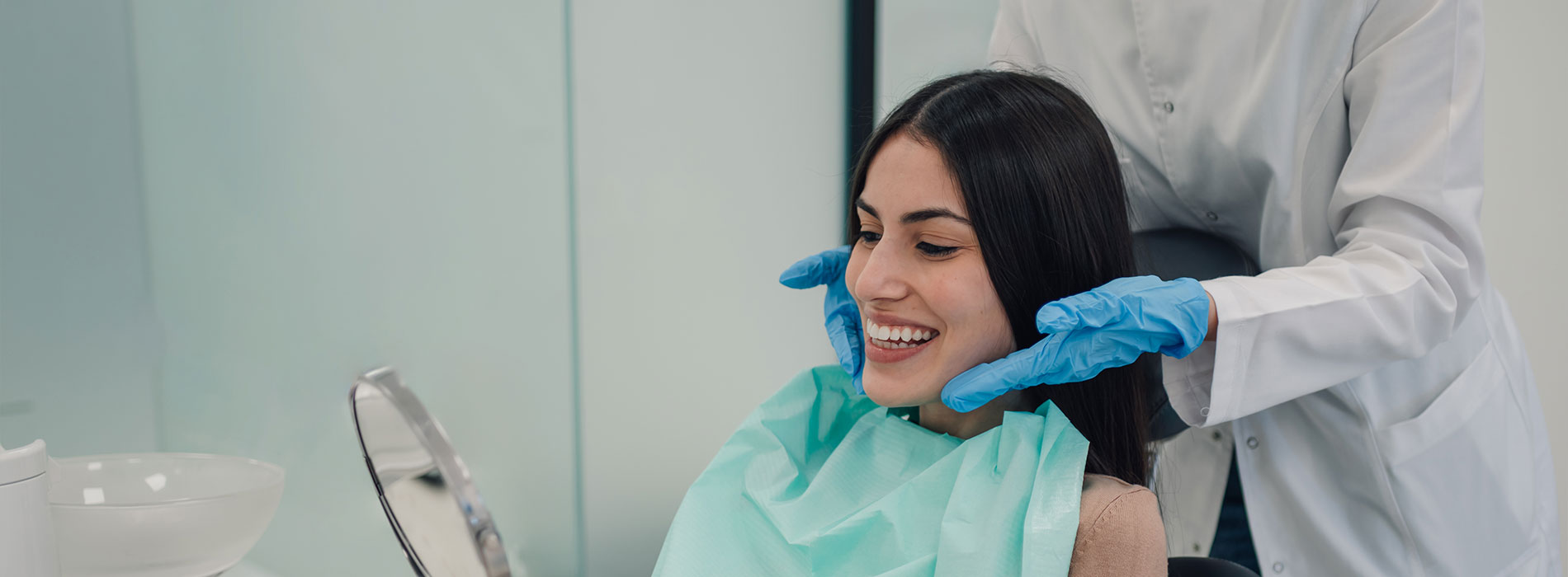 A well-lit reception area with a desk, computer monitor, and potted plant.
