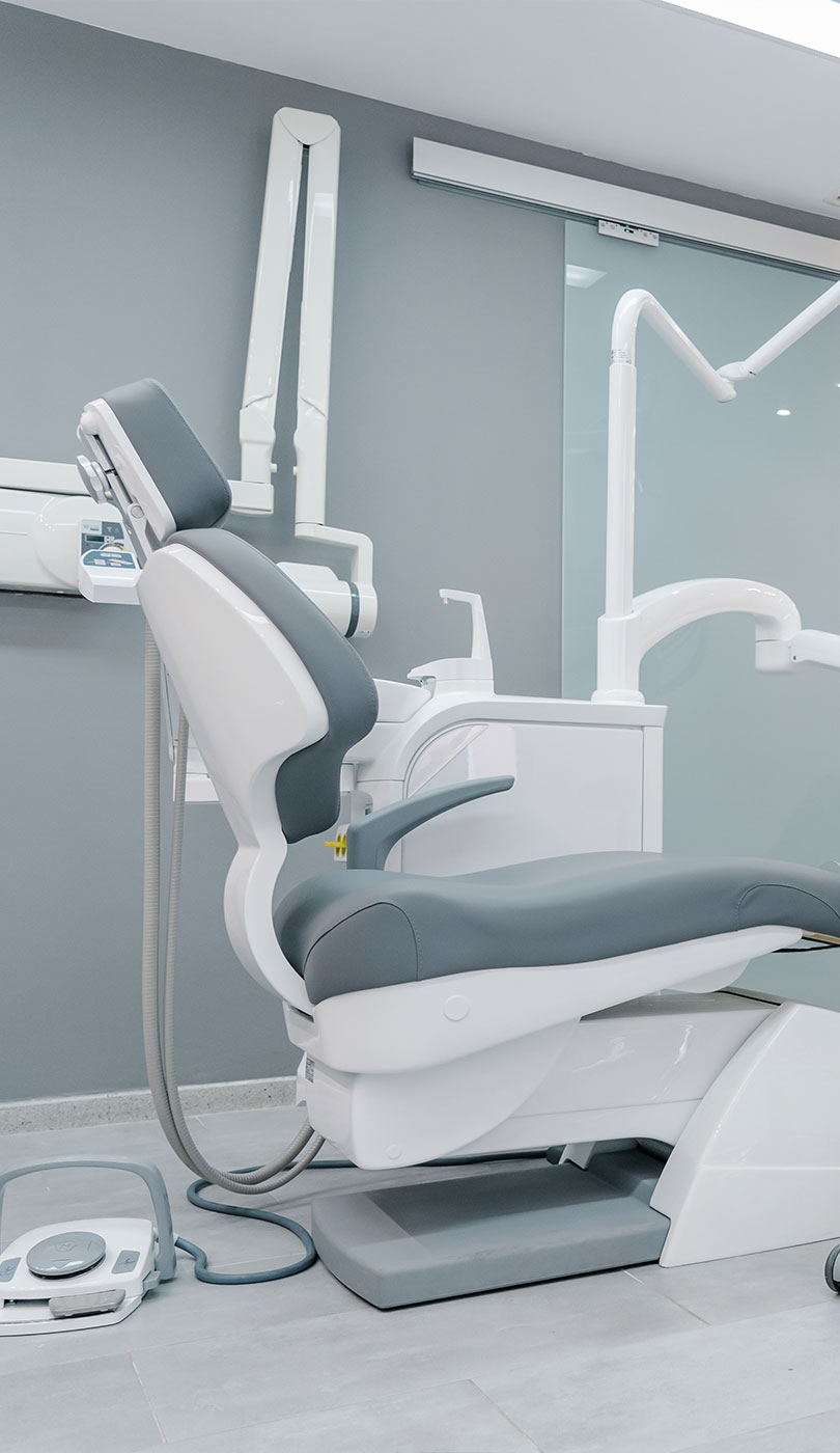 The image shows a modern dental or medical office interior with a dental chair, equipment, and a clean, professional environment.