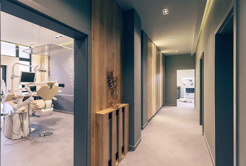 A photograph of three individuals, a man and two women, in a professional setting, seated on a couch with one woman holding an envelope while the others look at her.